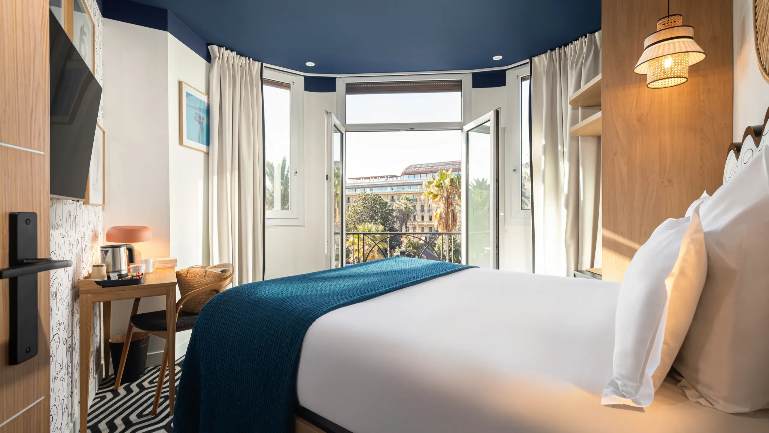 Chambre d'hôtel moderne avec balcon ensoleillé.