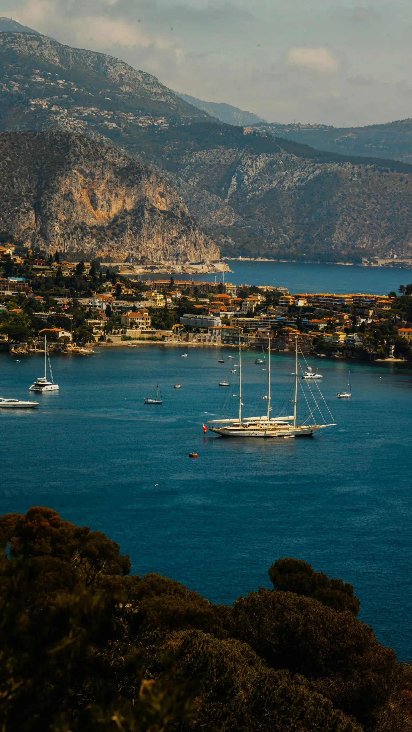 Voiliers sur une mer entourée de montagnes.