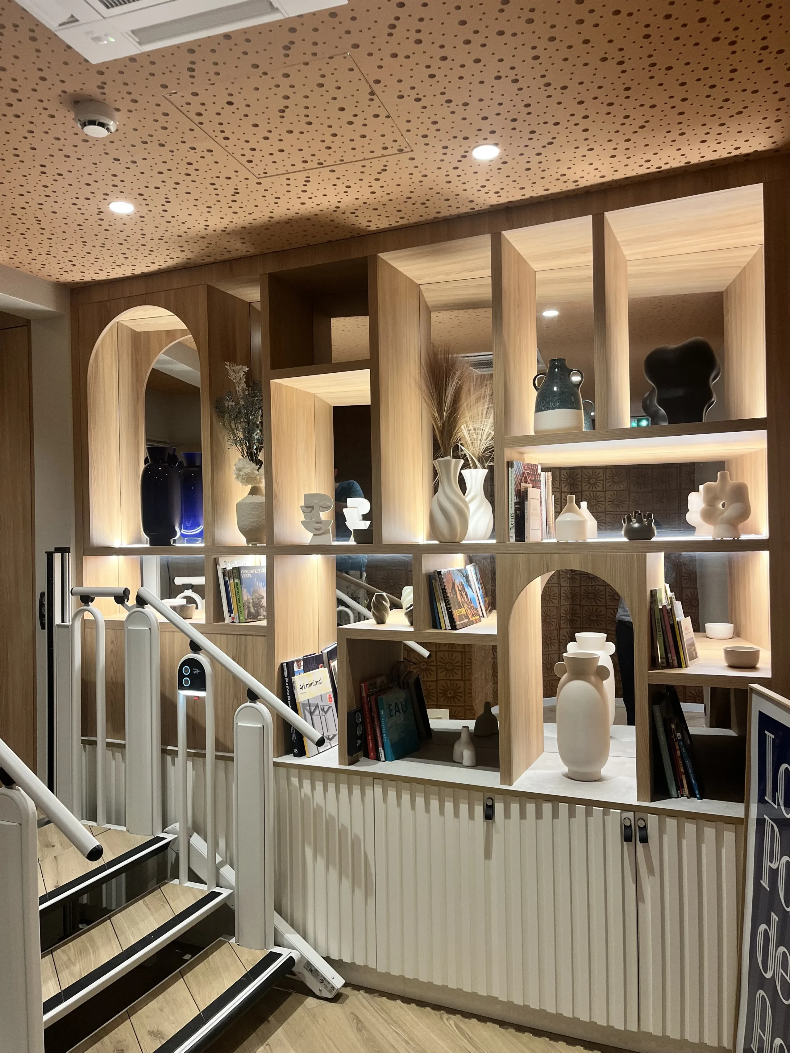 Étagère moderne en bois avec décorations et livres.